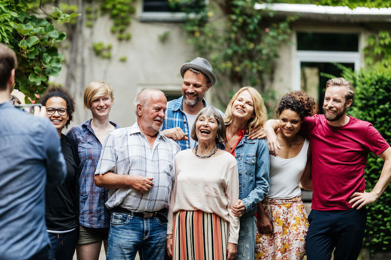 Getty Images Foto: Menschen stehen lachend nebeneinander und lassen sich fotografieren