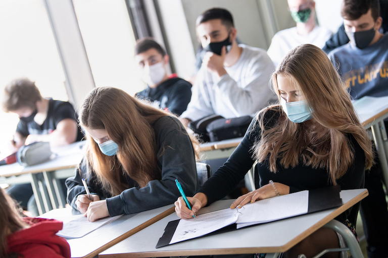 Foto: Schülerinnen und Schüler nehmen mit Mund- und Nasenschutz am Unterricht teil