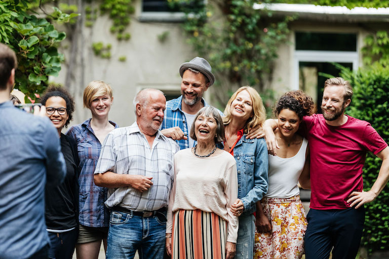 Foto: Menschen stehen lachend nebeneinander und lassen sich fotografieren