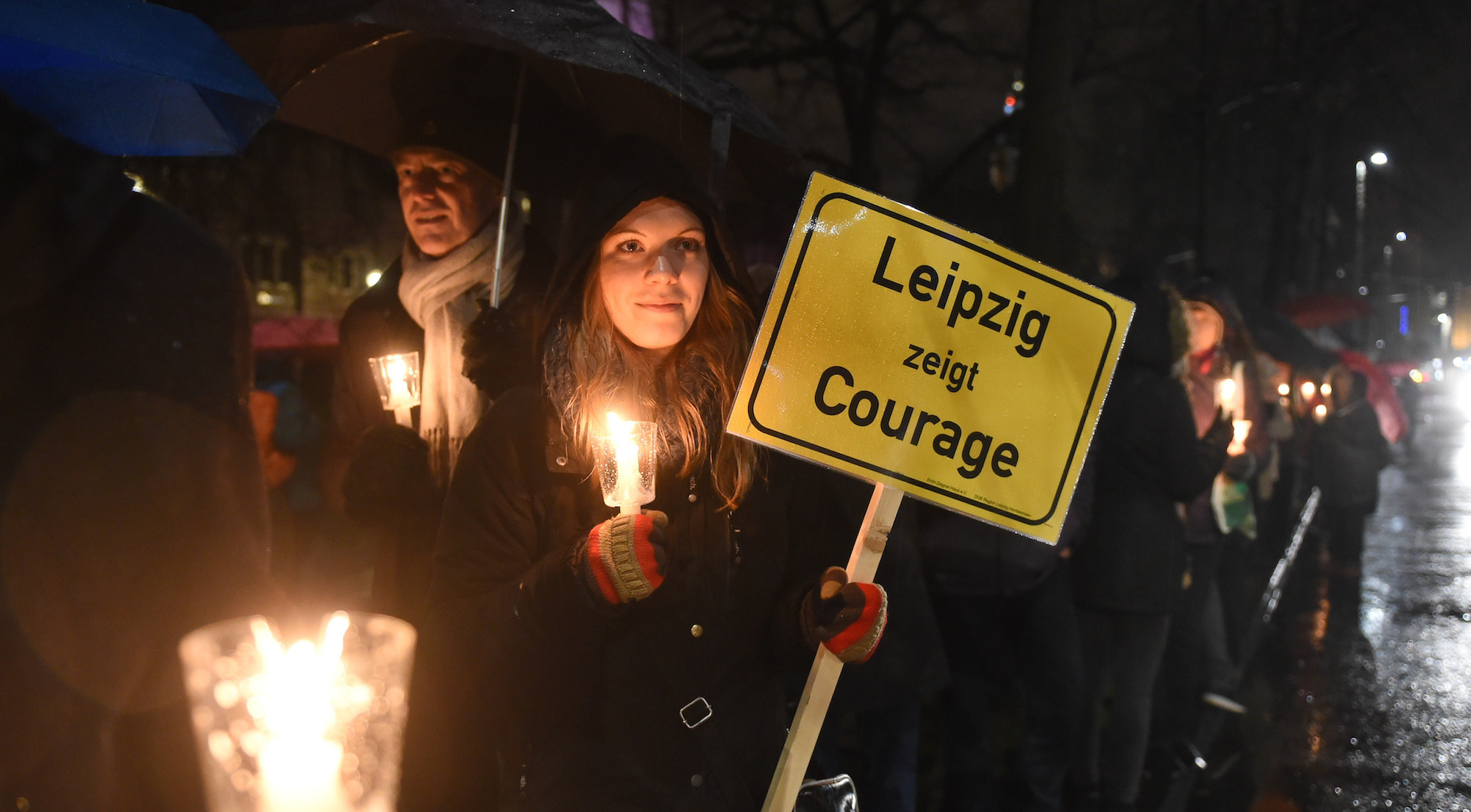Foto: Eine Frau hält am 11.01.2016 in Leipzig ein Schild mit der Aufschrift "Leipzig zeigt Courage" in der Hand und demonstriert damit gegen das islamkritische Legida-Bündnis.
