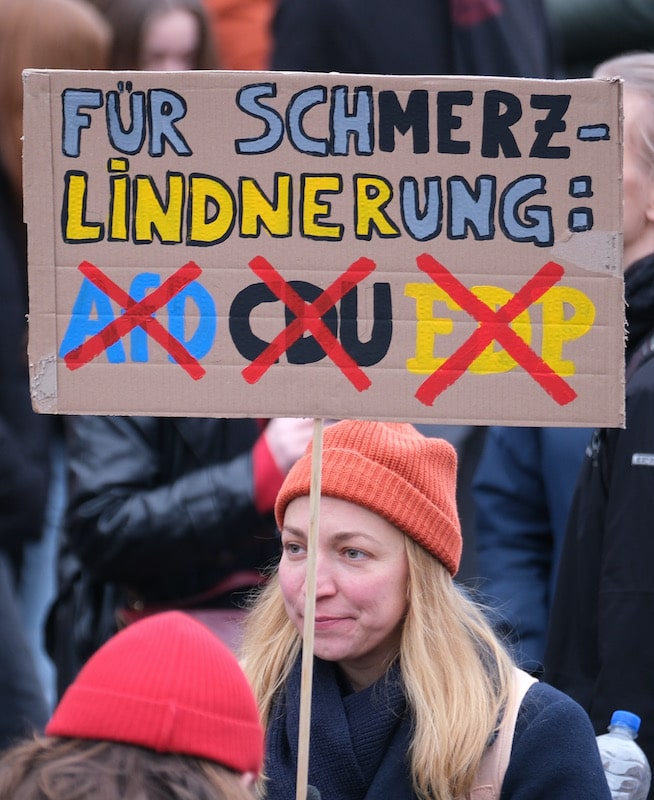 Foto: Schild mit Aufschrift "Für SchMerz-Lindnerung" ist bei Demonstration in Leipzig zu sehen