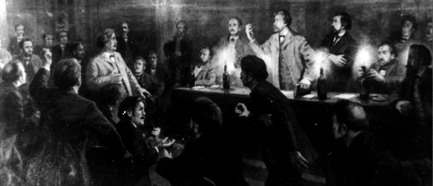 AdsD/FES Foto: Adolf Hepner, Wilhelm Liebknecht (mit erhobenem Arm) und August Bebel diskutieren auf dem Podium beim 6. Vereinstag des Verbandes der deutschen Arbeitervereine in Eisenach, 1869