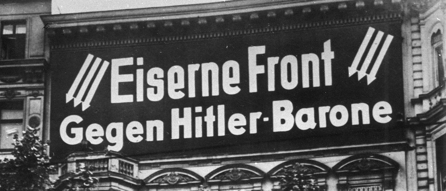 Foto: Gebäude-Transparent "Gegen Hitler-Barone". Drei Pfeile, Emblem der Eisernen Front, um 1933
