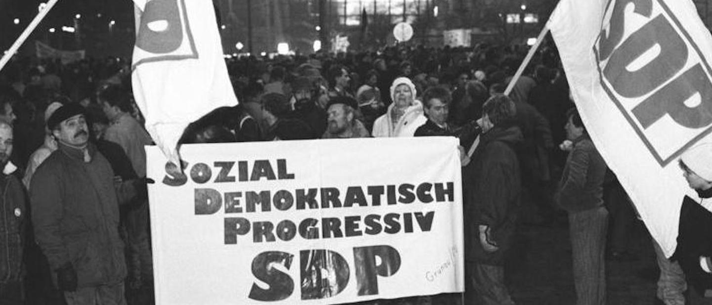 Foto: SDP-Anhänger mit Fahnen und Transparent auf Montagsdemo in Leipzig 1990